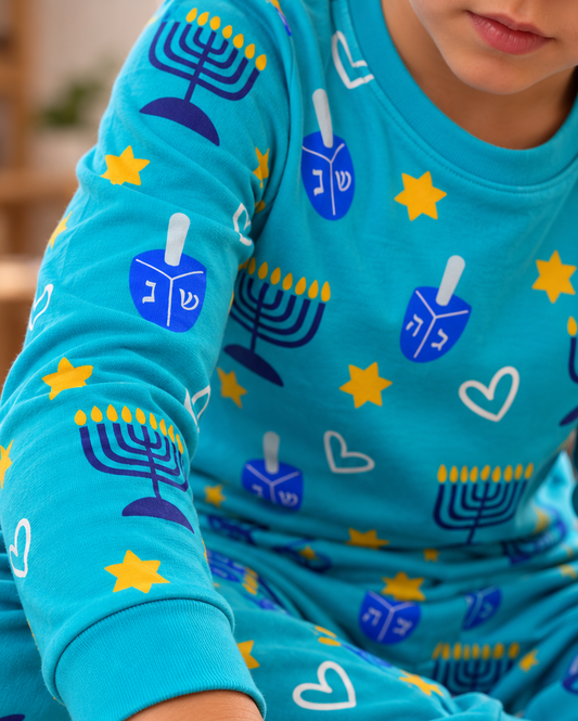 Shine Bright Hanukkah two-piece kids' pajama set in turquoise with menorah and dreidel print