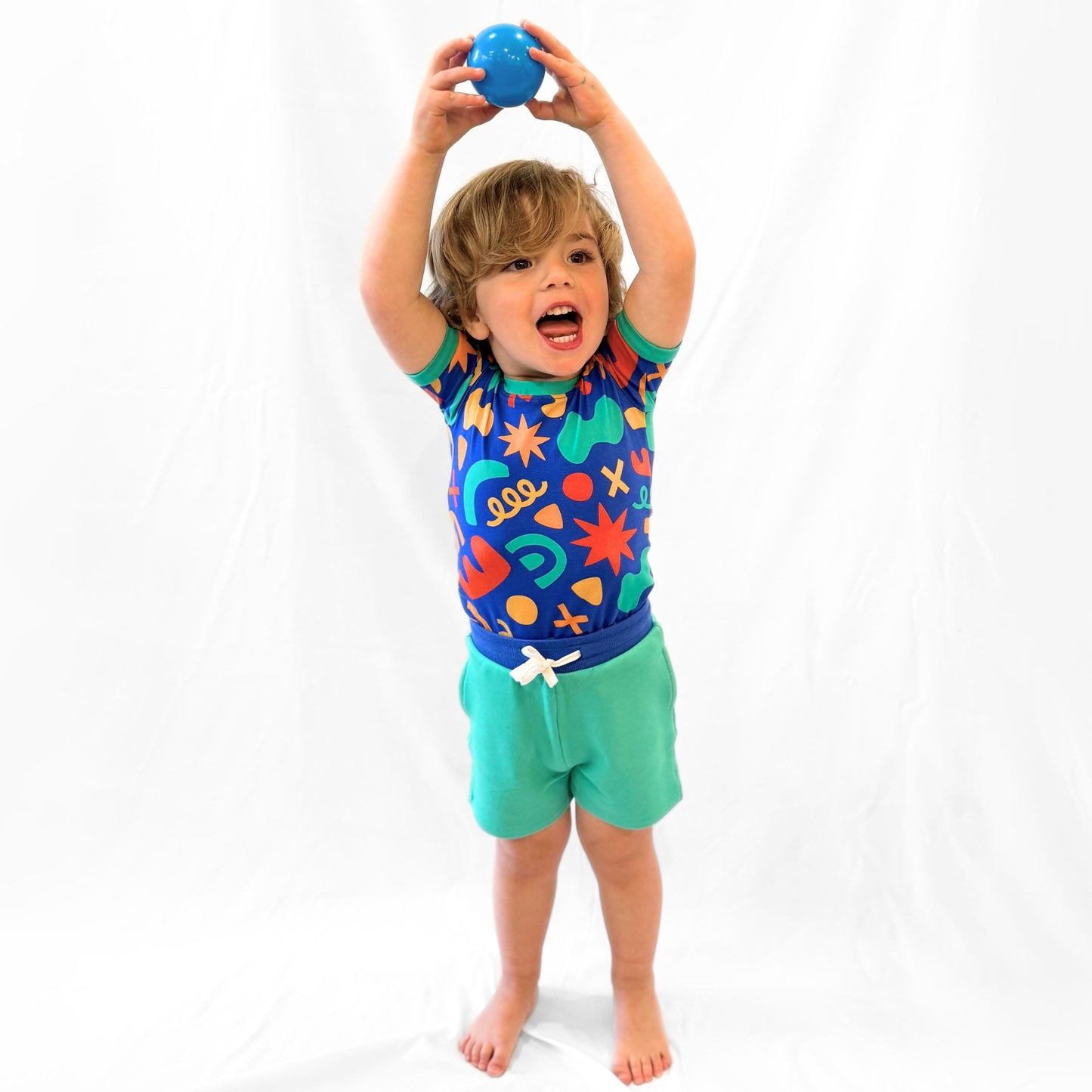 Colorful toddler swim suit featuring playful patterns, blue top and green shorts, perfect for summer fun.