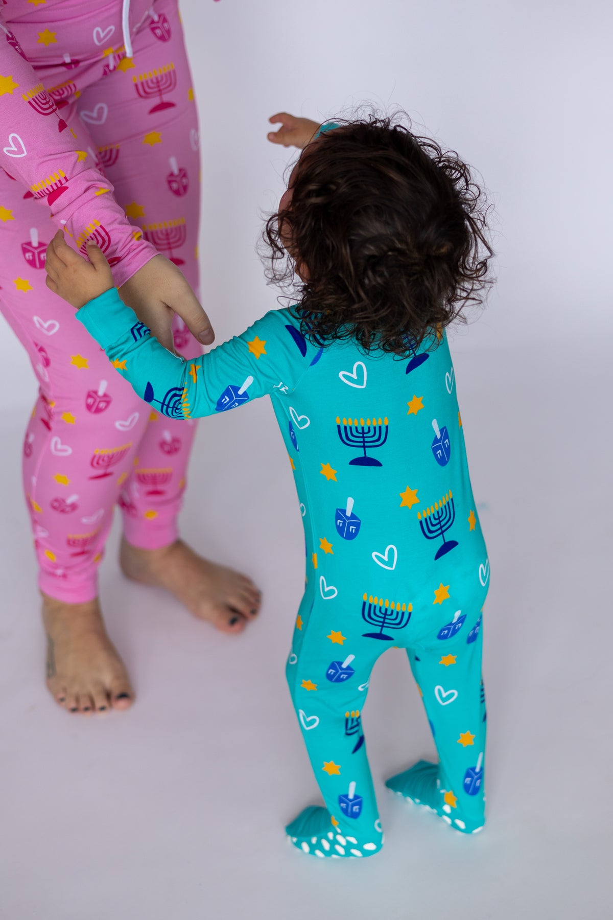 Matching holiday pajamas for kids and adults, featuring colorful Hanukkah patterns, lightweight and cozy fabric.