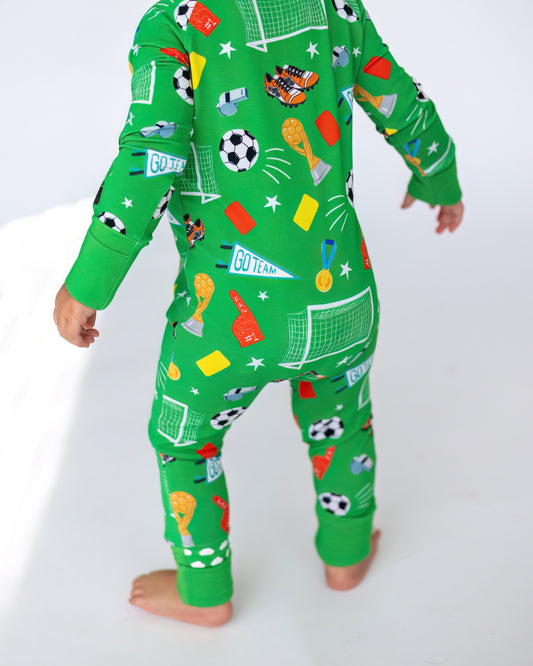 Kids' green soccer-themed pajamas with playful patterns, made from comfortable cotton fabric.
