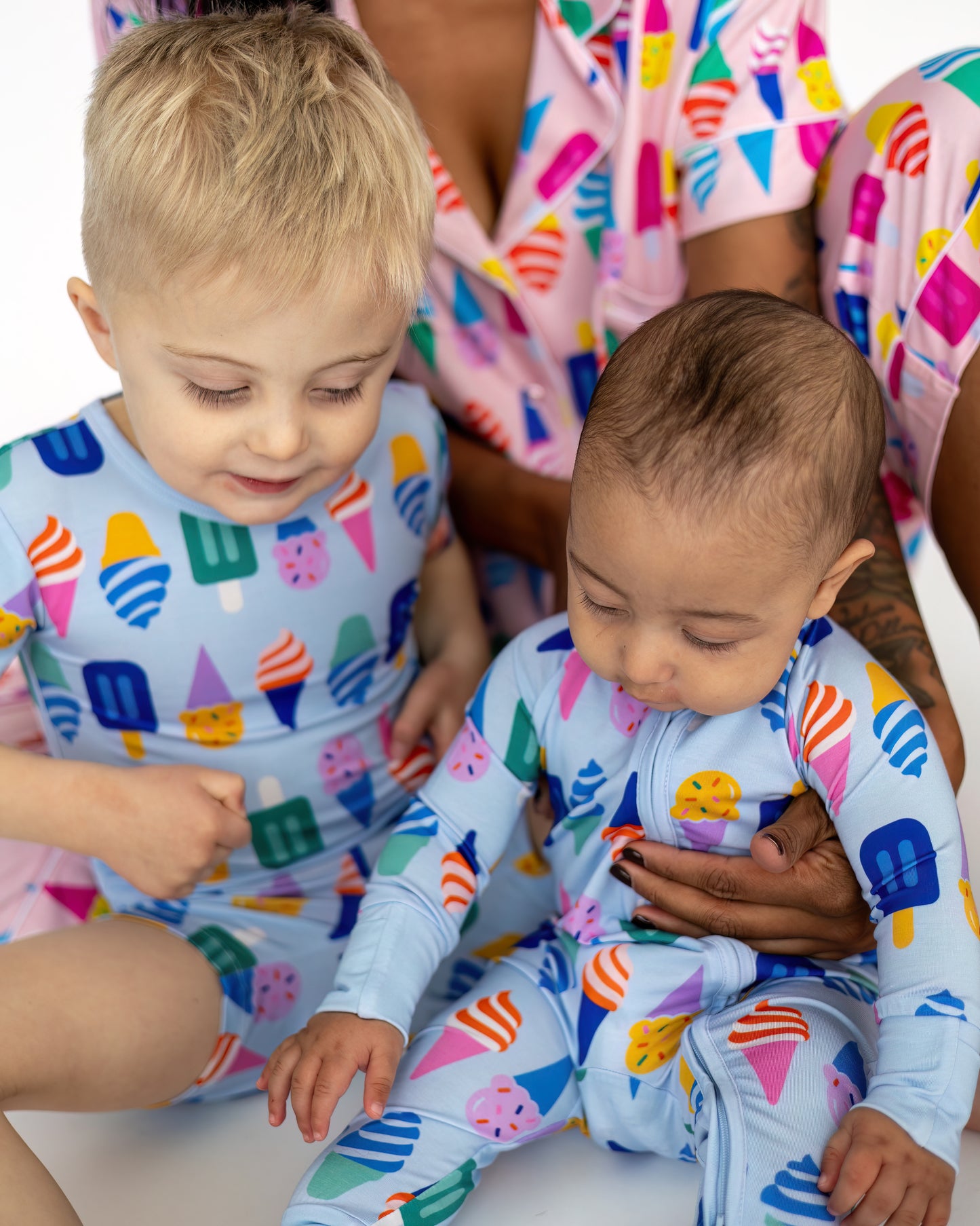 Matching kids' swimwear, light blue with colorful ice cream prints, soft, stretchy fabric for comfort.