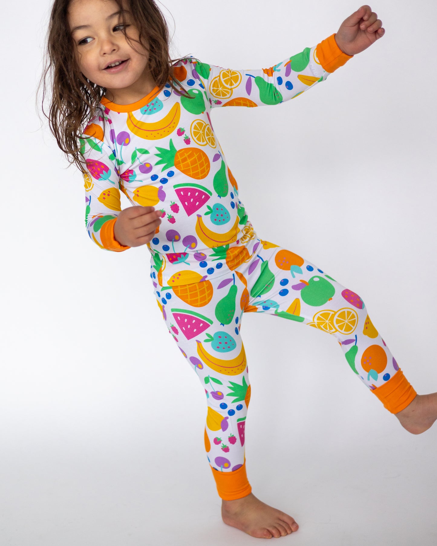 Colorful kids' fruit-patterned pajama set, long sleeves and pants, soft fabric, vibrant colors, size options available.