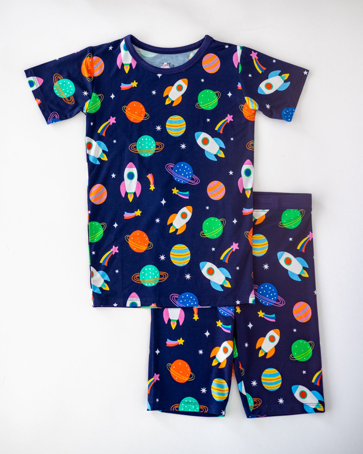 Kids' navy blue pajama set featuring colorful rockets and planets, made from soft, breathable fabric.