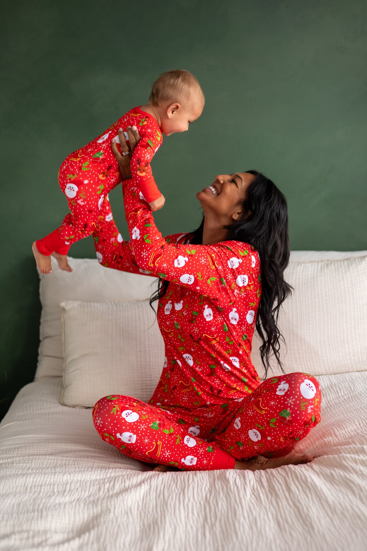 Matching red holiday pajamas for mom and baby featuring fun snowman design, soft and cozy fabric.