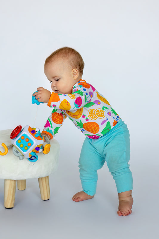 Colorful fruit-patterned baby bodysuit with aqua pants, perfect for playful toddler moments.