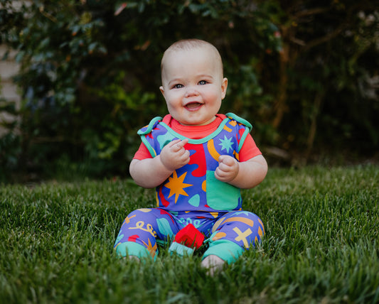 Colorful patterned baby outfit in blue, red, and green with fun designs, perfect for infants.