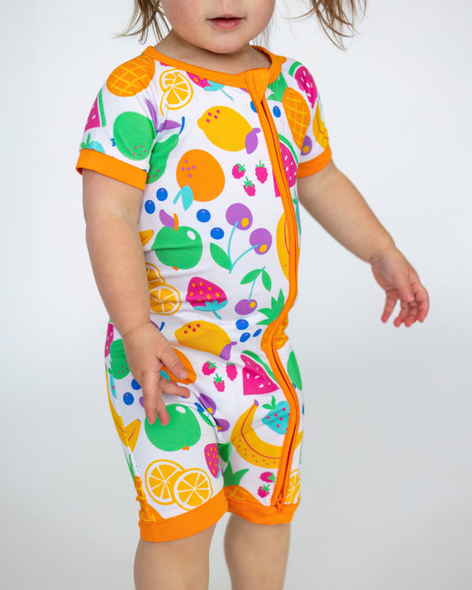 Colorful toddler onesie featuring fruit patterns, short sleeves, and orange accents, made from soft fabric.