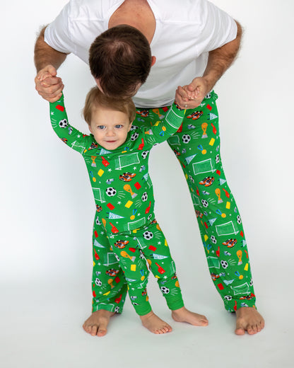 Matching green sports-themed pajamas for dad and toddler, made from soft fabric, perfect for playtime.