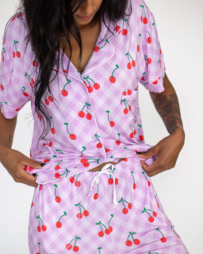 Women's cherry print pajama set in light purple, made from soft fabric with a comfortable fit.