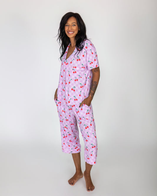 Women's cherry print pajama set in pink, short-sleeved top and cropped pants, made from soft cotton.