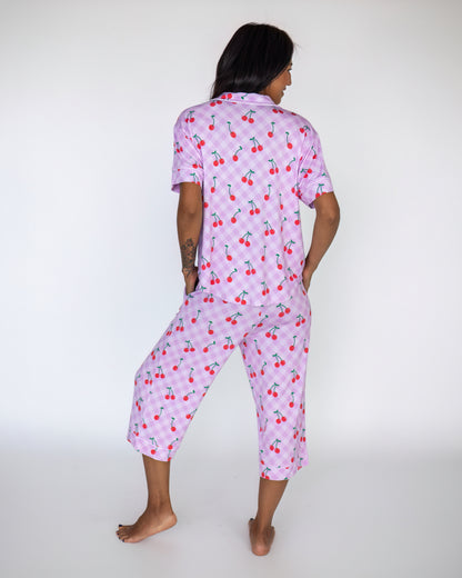 Women's cherry print pajama set in light purple, featuring short sleeves and cropped pants.