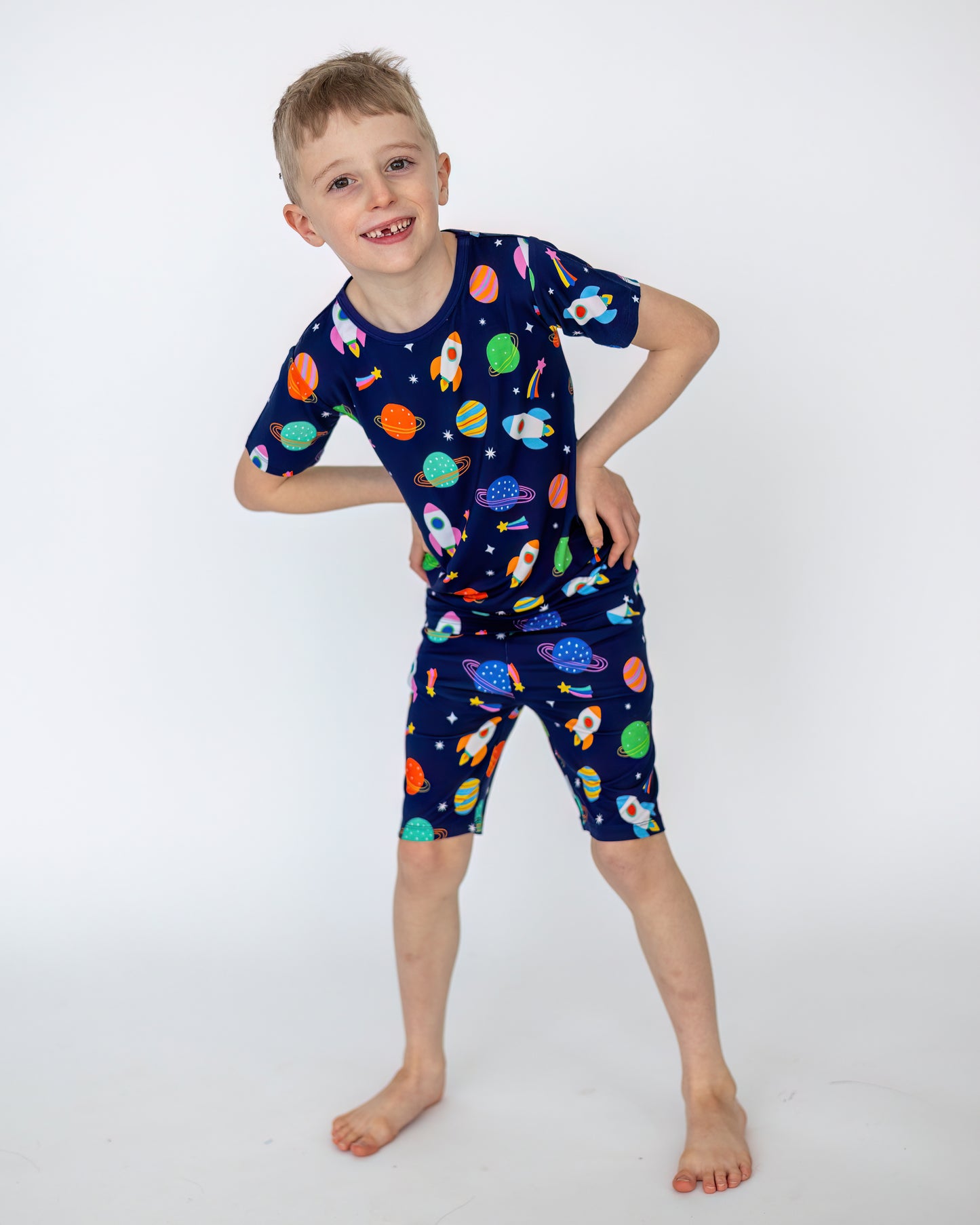 Boys' space-themed pajama set in navy blue, featuring rockets and planets; made from soft, breathable fabric.
