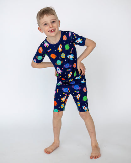Boys' space-themed pajama set in navy blue, featuring rockets and planets; made from soft, breathable fabric.