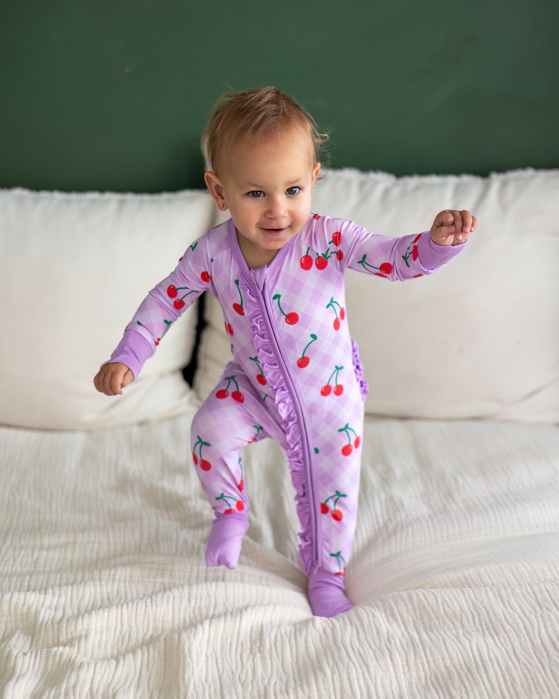 Infant cherry print romper in lavender with ruffles, perfect for playful moments.
