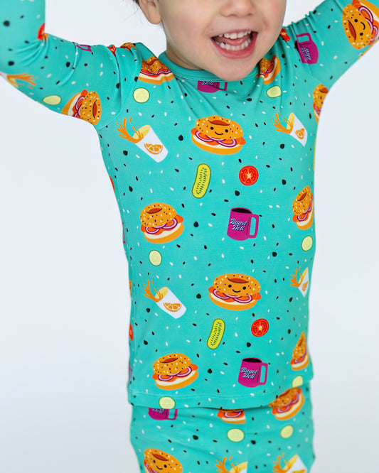 Cute turquoise kids' pajamas featuring fun food prints, made from soft, breathable material.