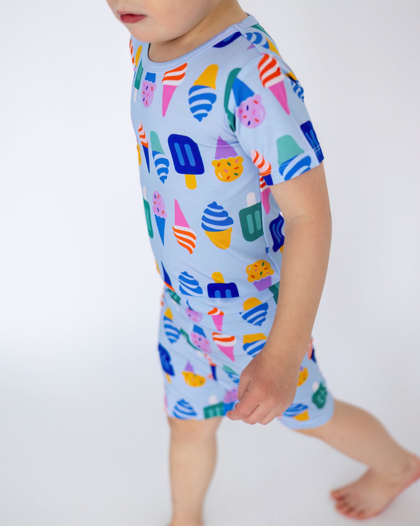 Kids' short-sleeve pajama set in light blue, featuring colorful ice cream patterns, made from soft cotton.