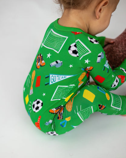 Kids' green soccer-themed pajamas featuring fun patterns of balls, whistles, and goal posts.