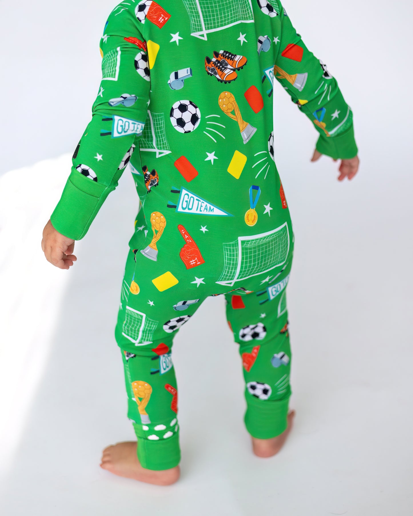 Kids' green soccer-themed pajamas with playful patterns, made from comfortable cotton fabric.