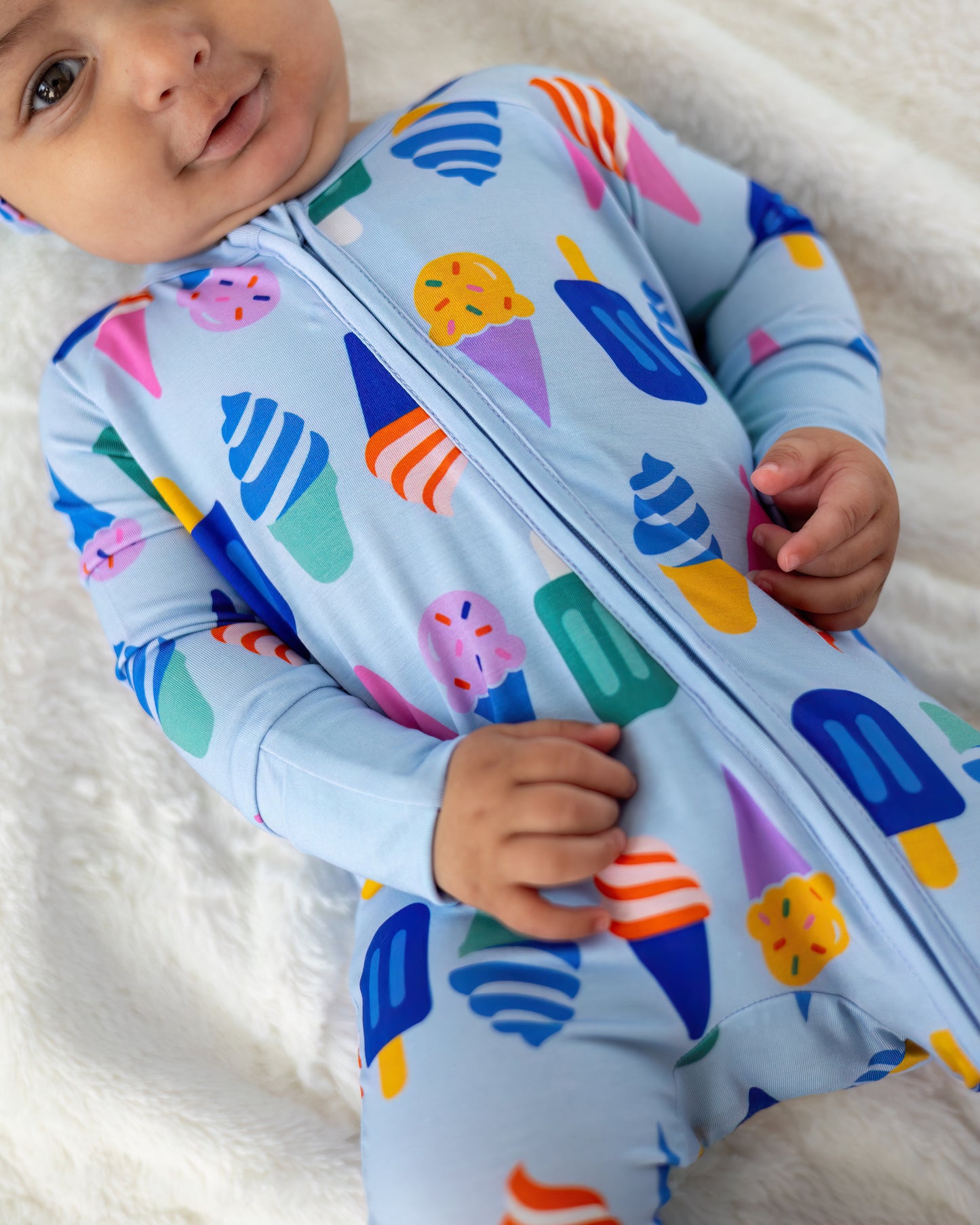 Cute blue baby onesie with colorful ice cream prints, made from soft stretchy material, perfect for toddlers.
