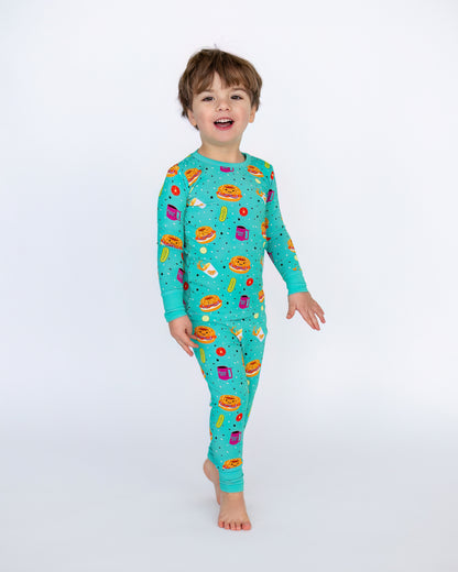 Kids' turquoise pajama set with fun food prints, made from soft stretchable fabric for comfort.