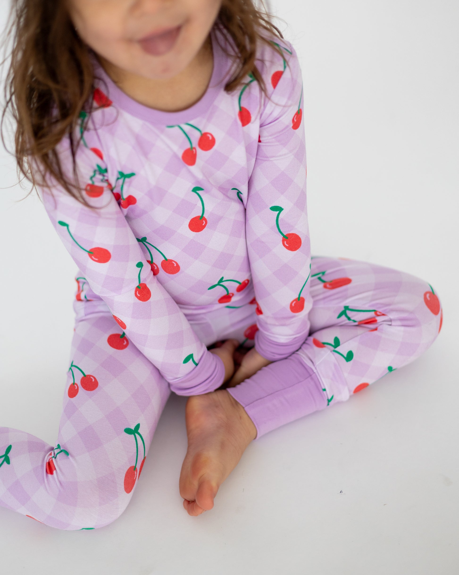 Kids' long sleeve pajamas in lavender with cherry print, made from soft cotton for comfort.