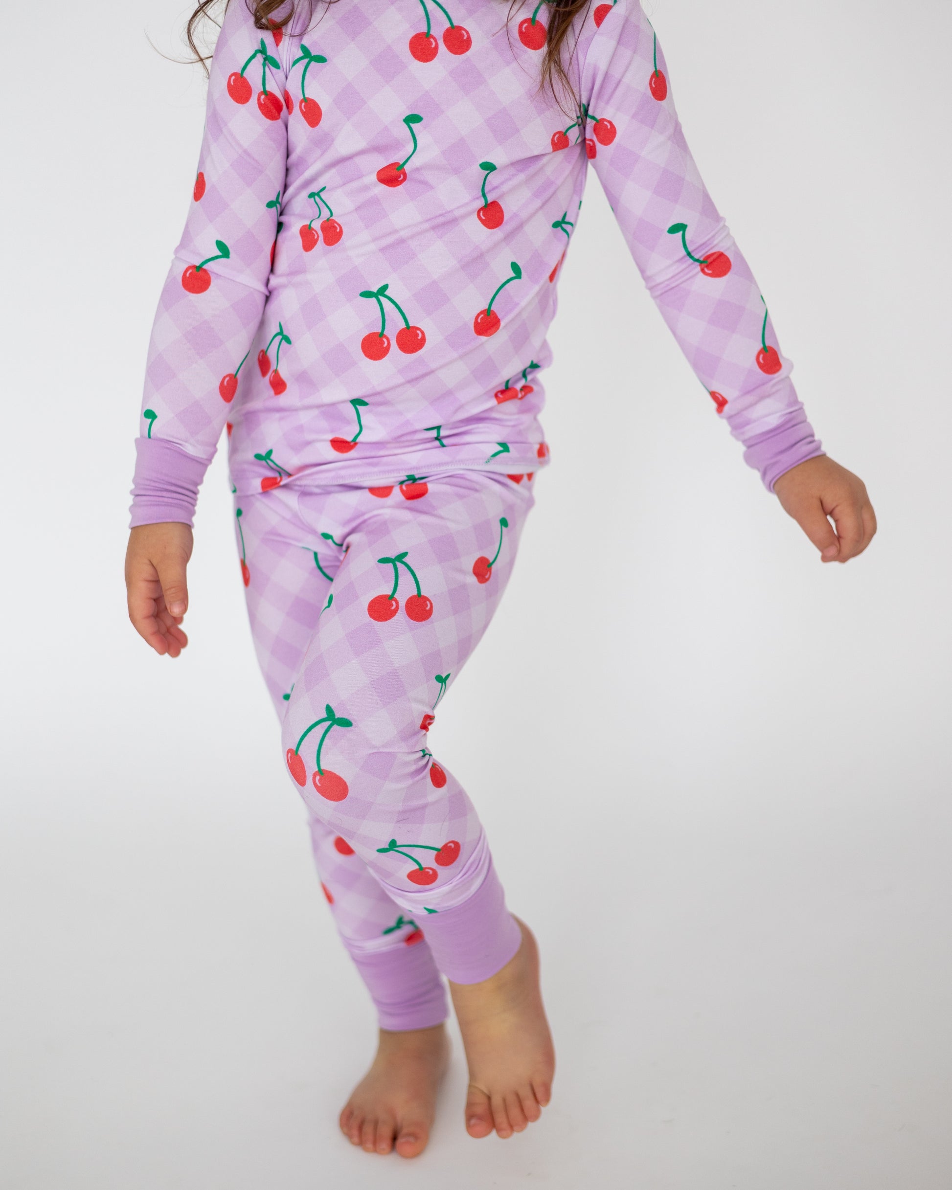 Kids' long sleeve pajama set in lavender with cherry print, soft cotton material, perfect for comfortable sleep.