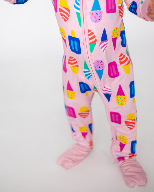 Kids' pink onesie covered in colorful ice cream and popsicle prints, soft cotton fabric with footed design.