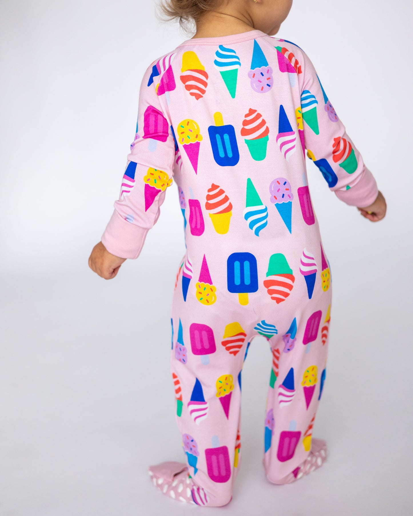 Colorful children's onesie featuring ice cream cone print in pink fabric, perfect for playtime or sleep.