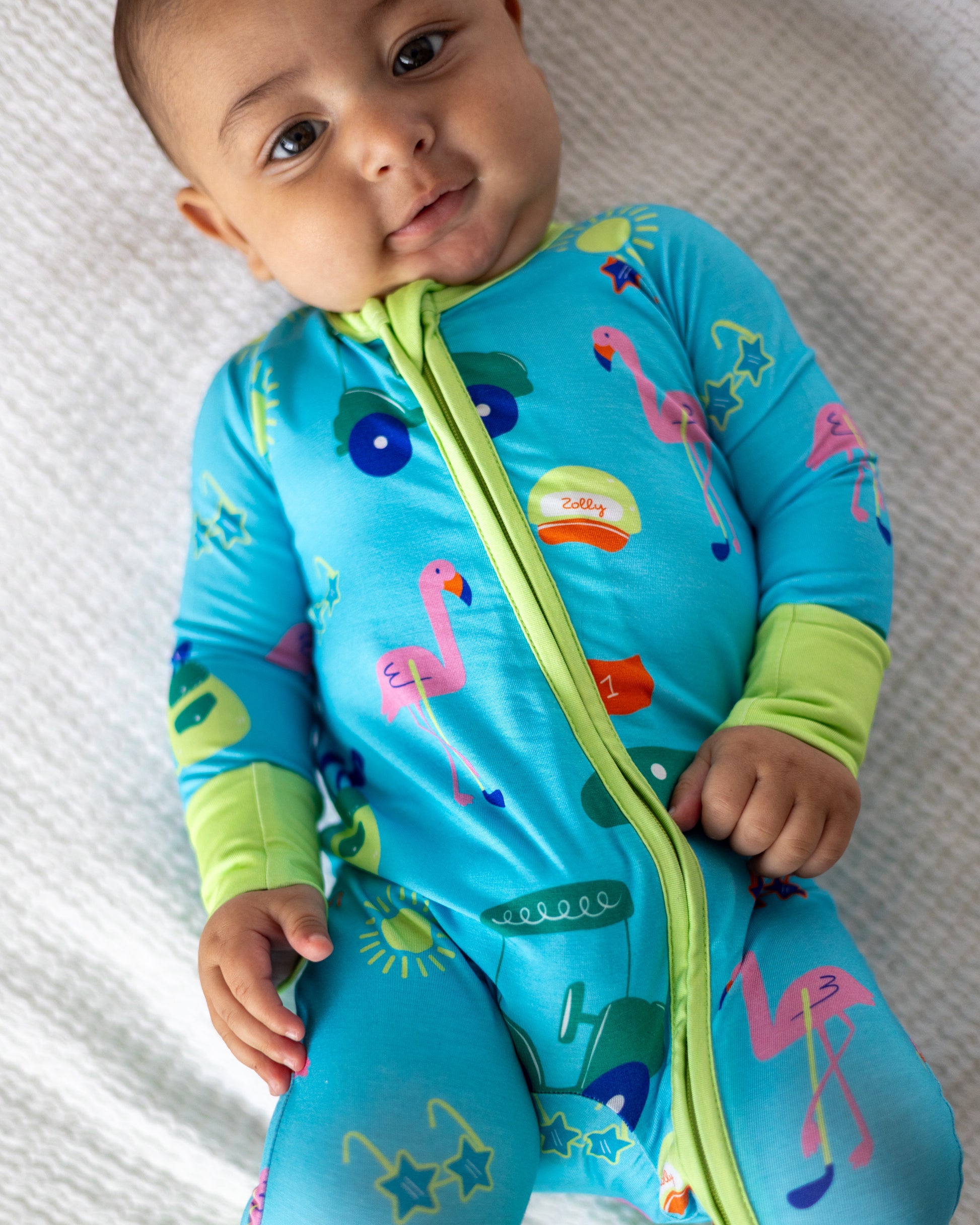 Colorful baby onesie in blue with flamingo and star patterns, made from soft, breathable material.
