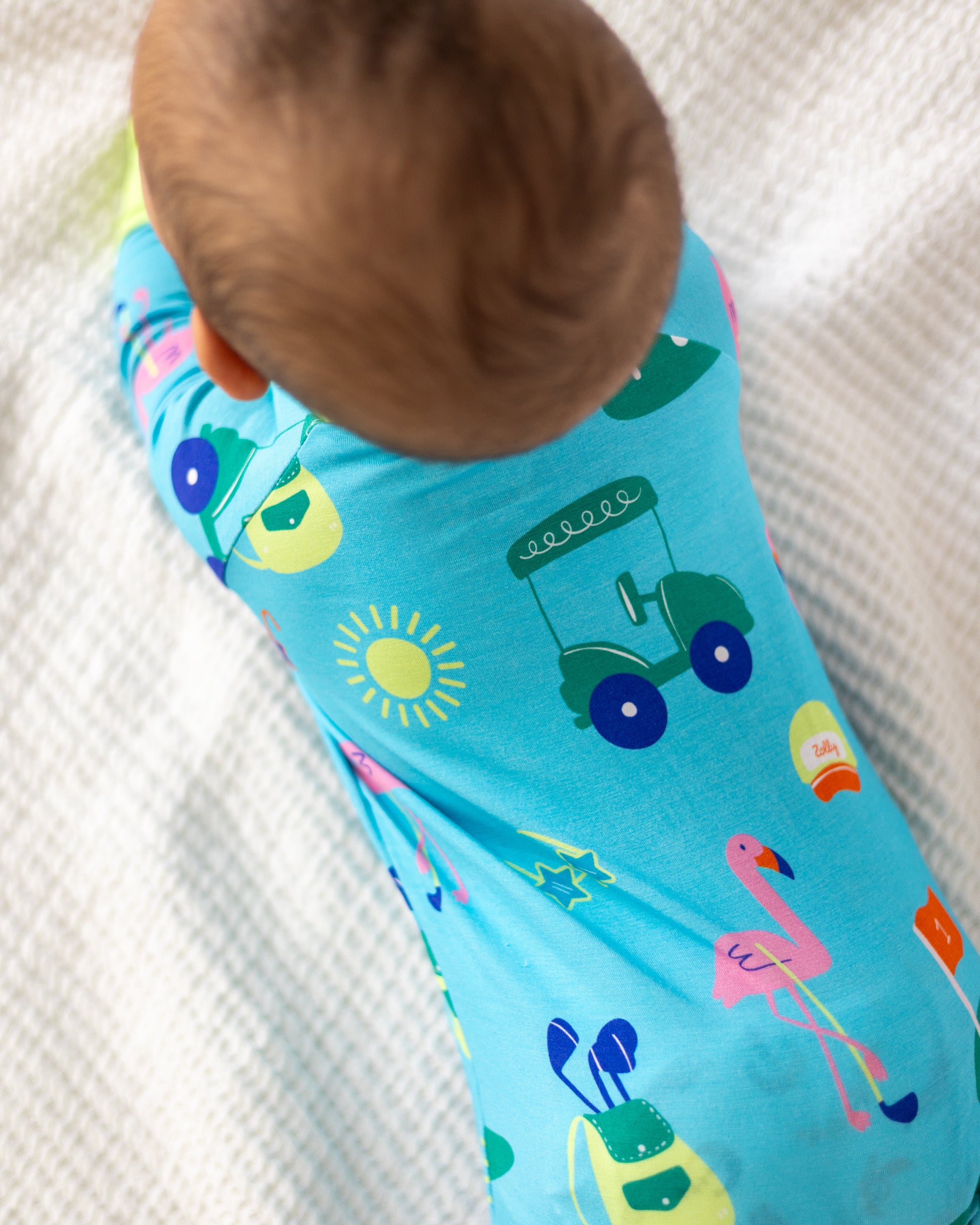 Baby boy's colorful short-sleeve pajama set in blue, featuring fun animal and object patterns.