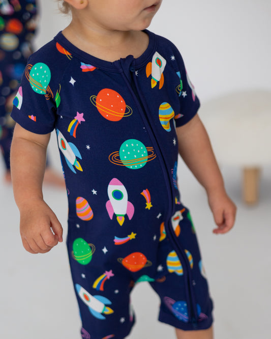 Navy blue toddler onesie featuring colorful rockets and planets, made from soft cotton for comfort.