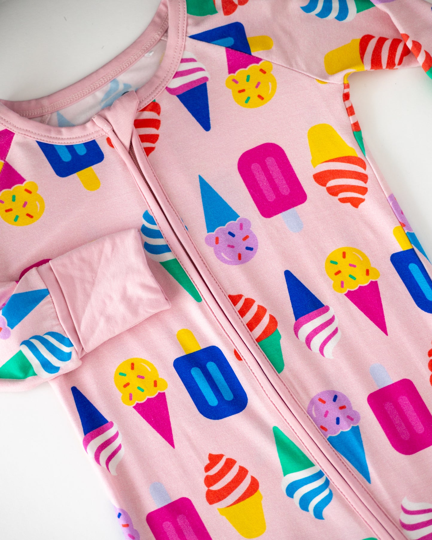 Pink ice cream print zip-up onesie for kids, made of soft cotton fabric, featuring colorful dessert patterns.