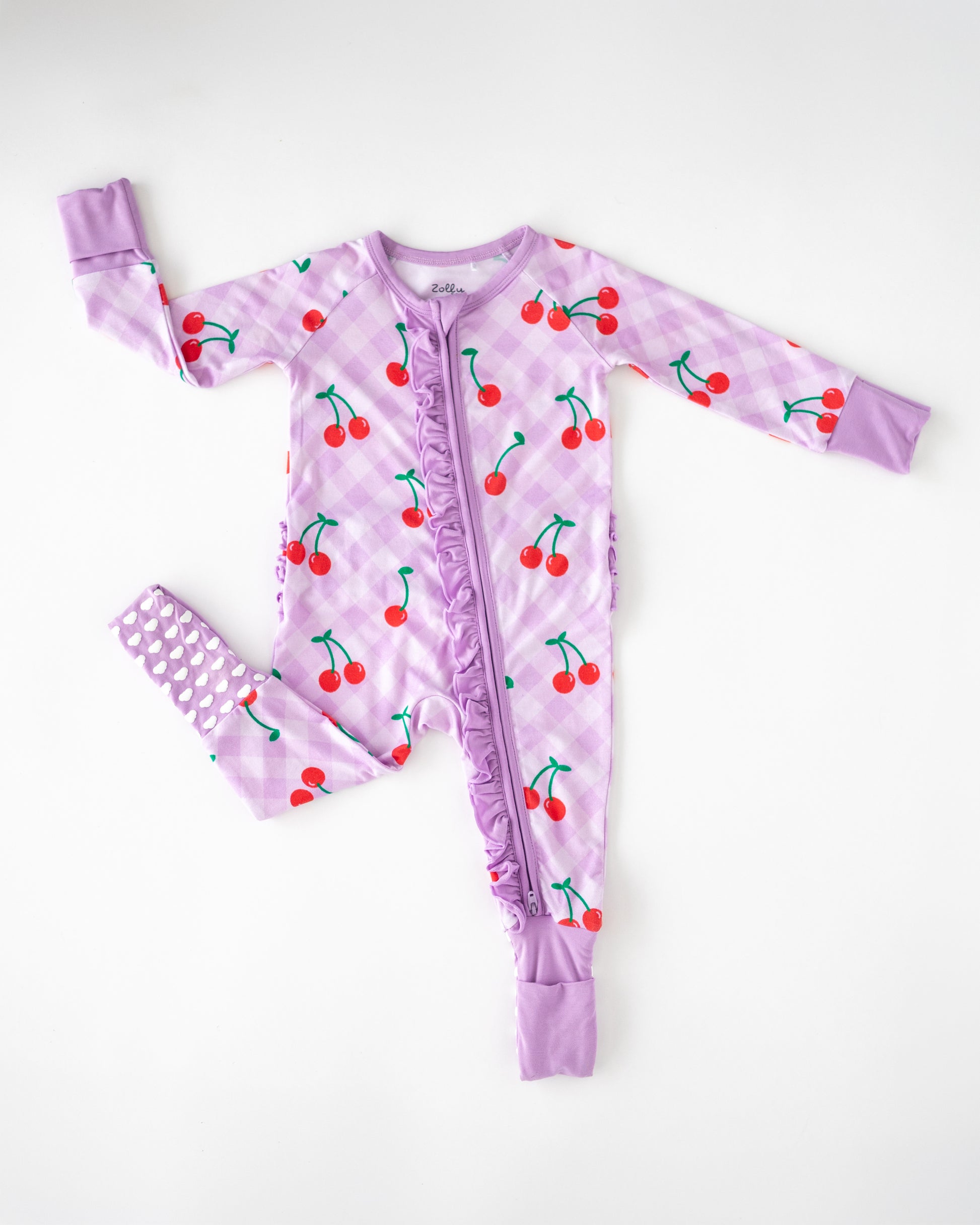 Children's purple cherry-print onesie with ruffles, cozy and stylish for playful comfort.