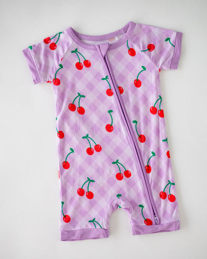 Kids' purple cherry print romper, featuring a front zipper and short sleeves, made from soft cotton material.