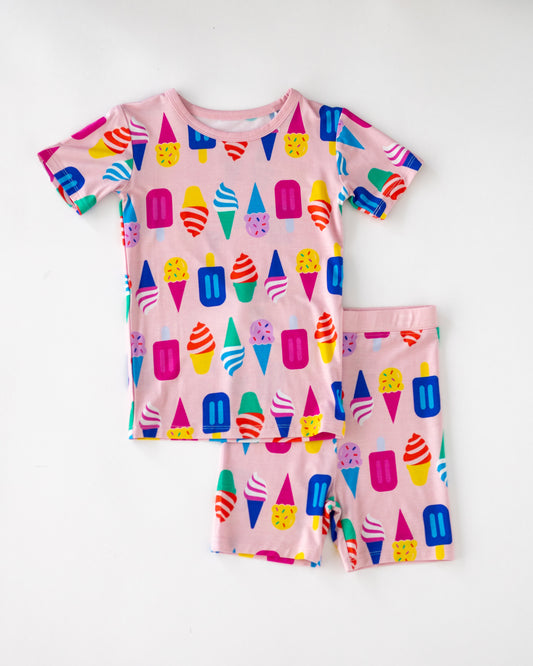 Colorful kids' short pajamas set with ice cream and popsicle patterns, made from soft cotton in pink.