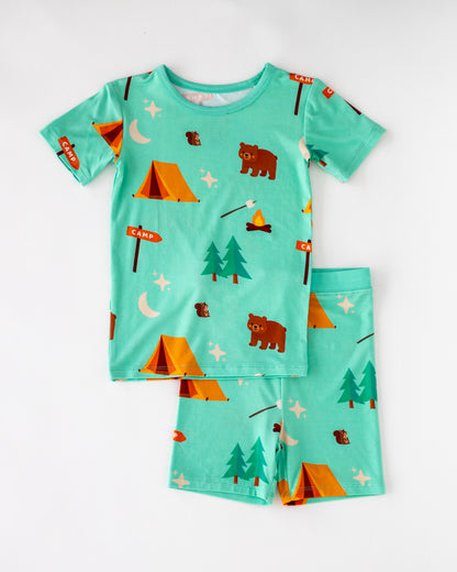 Children's camping-themed pajamas set, light blue, soft cotton, featuring bears, tents, and trees.