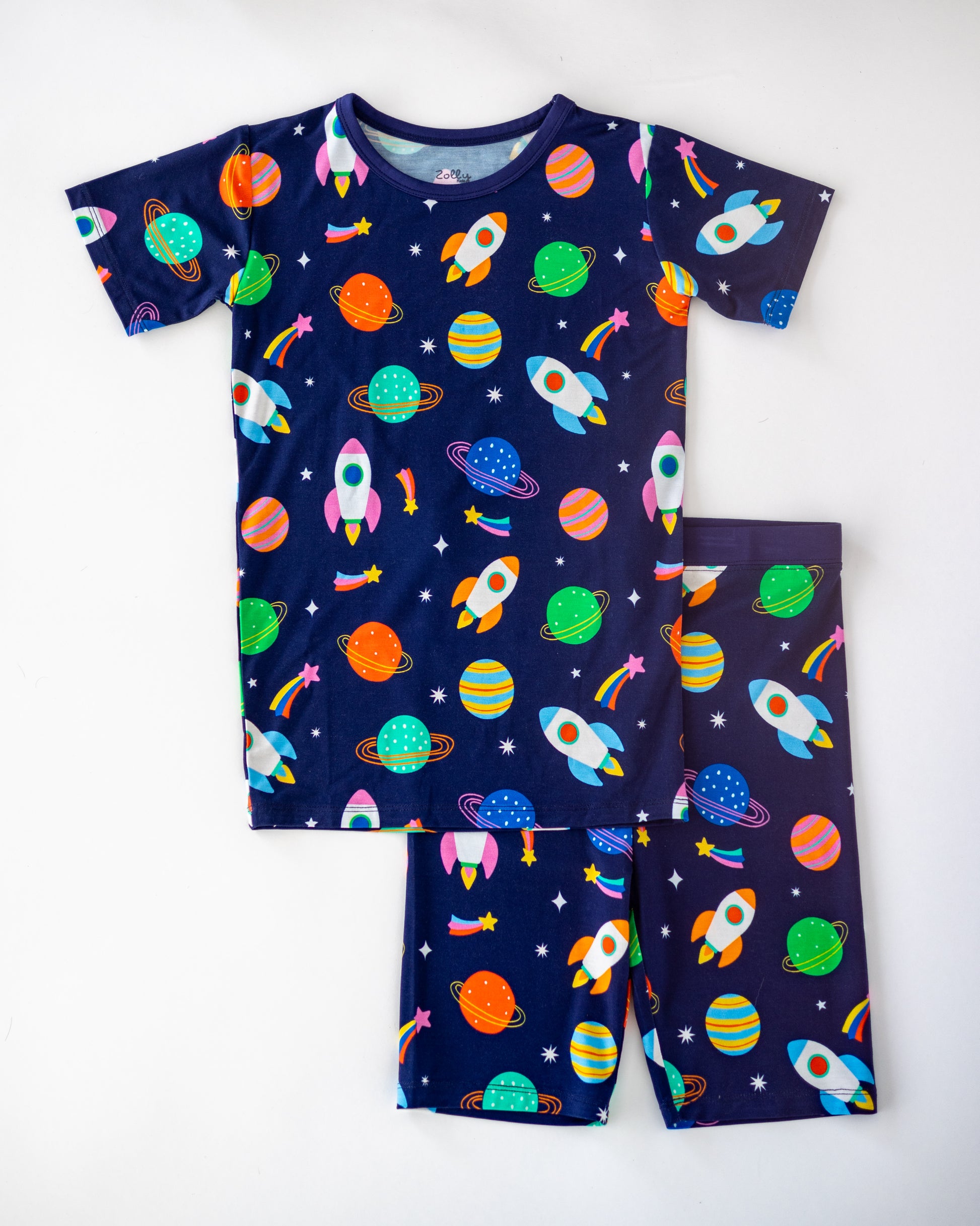 Kids' navy blue pajama set featuring colorful rockets and planets, made from soft, breathable fabric.