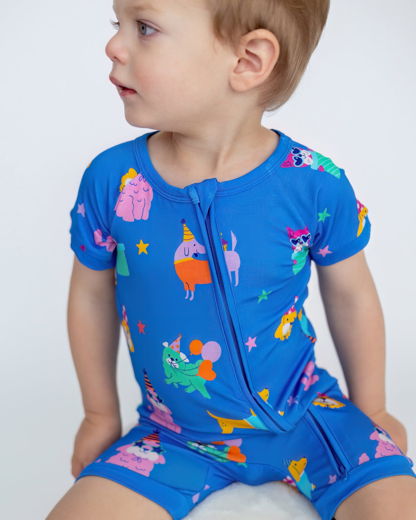 Colorful blue toddler play suit featuring fun animal and party designs, perfect for summer adventures.