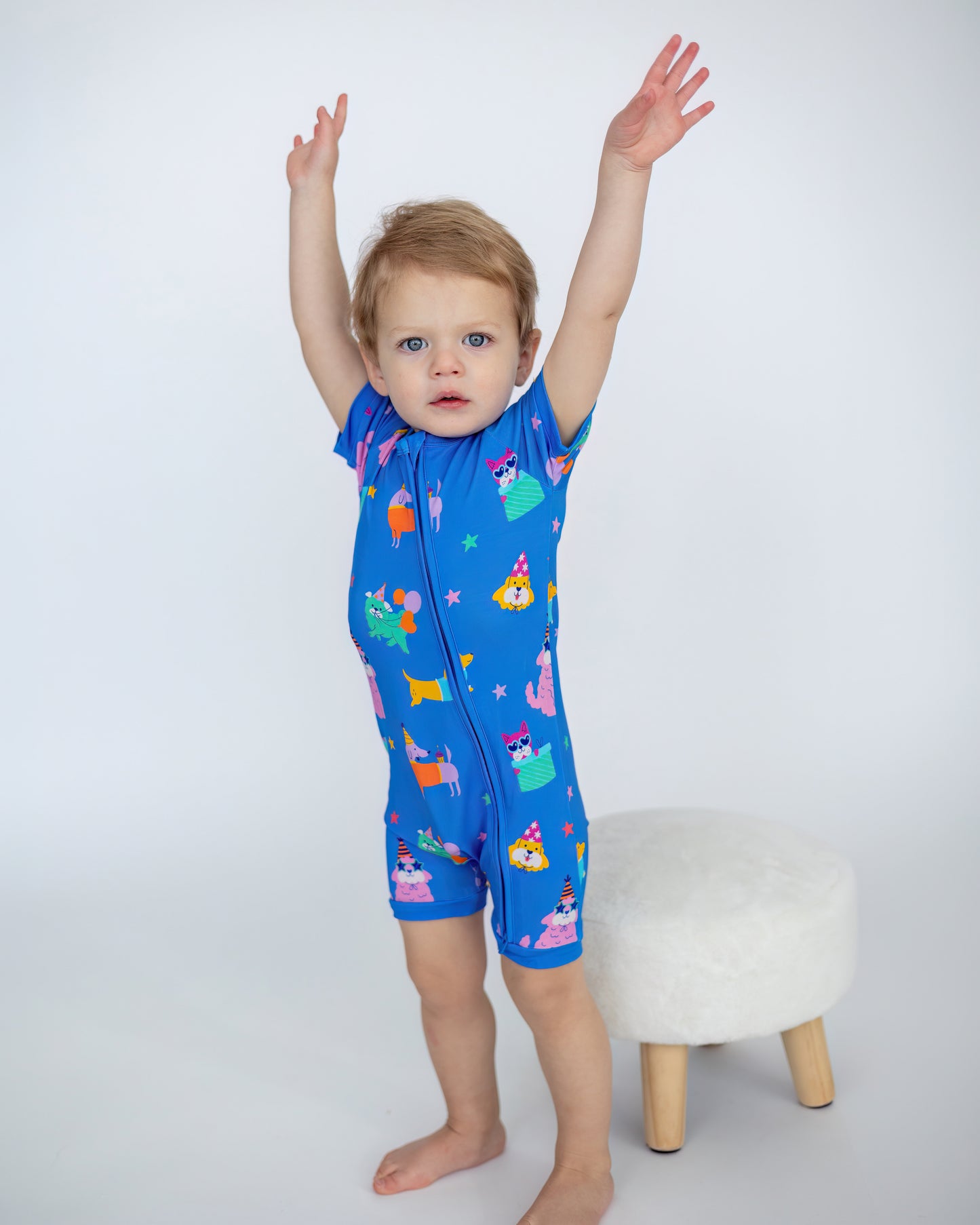 Colorful kids' short-sleeve swim suit in blue, featuring playful animal and party graphics, perfect for summer.