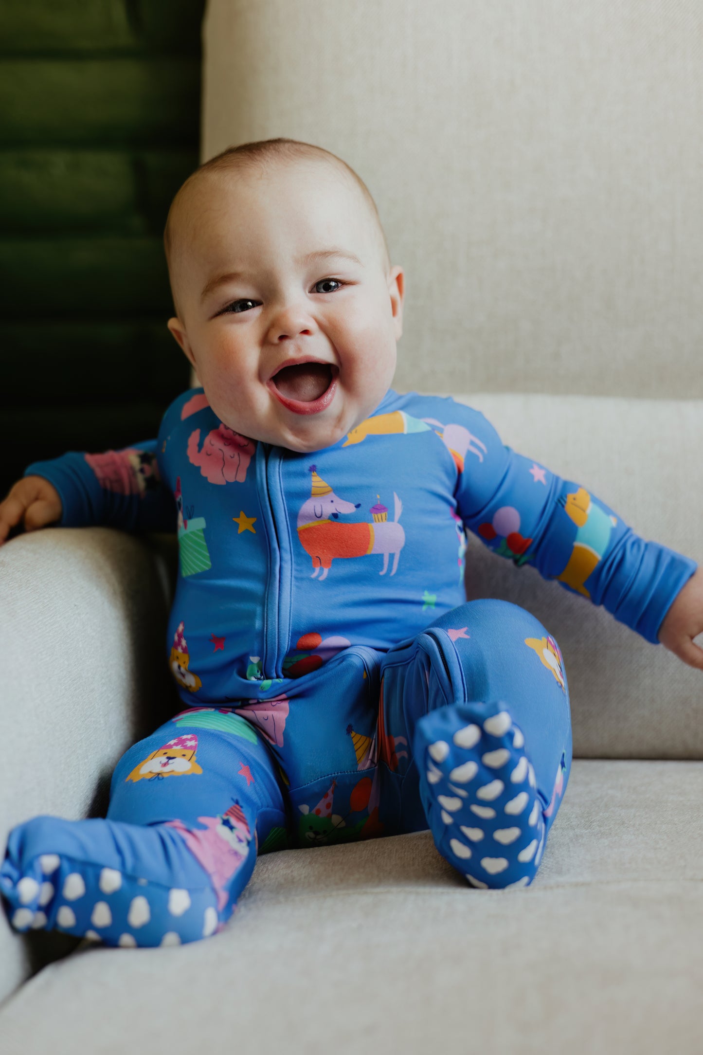 Smiling baby in colorful blue onesie with fun animal patterns, perfect for cozy, playful moments.