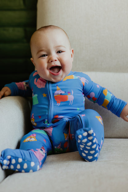 Smiling baby in colorful blue onesie with fun animal patterns, perfect for cozy, playful moments.